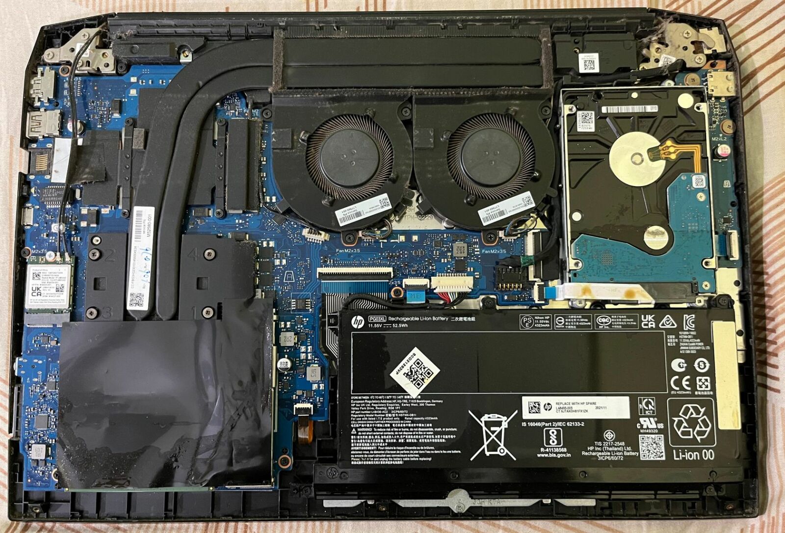 The underside of a laptop with the back removed and internal battery revealed.